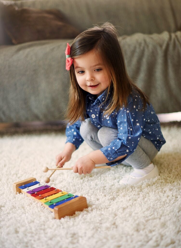 Little girl playing the xylophone learning music