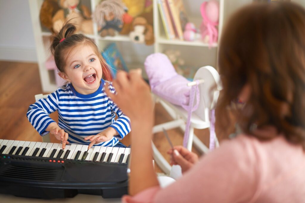 mother and daughter singing together and playing music, little girl learns to sing with her mom