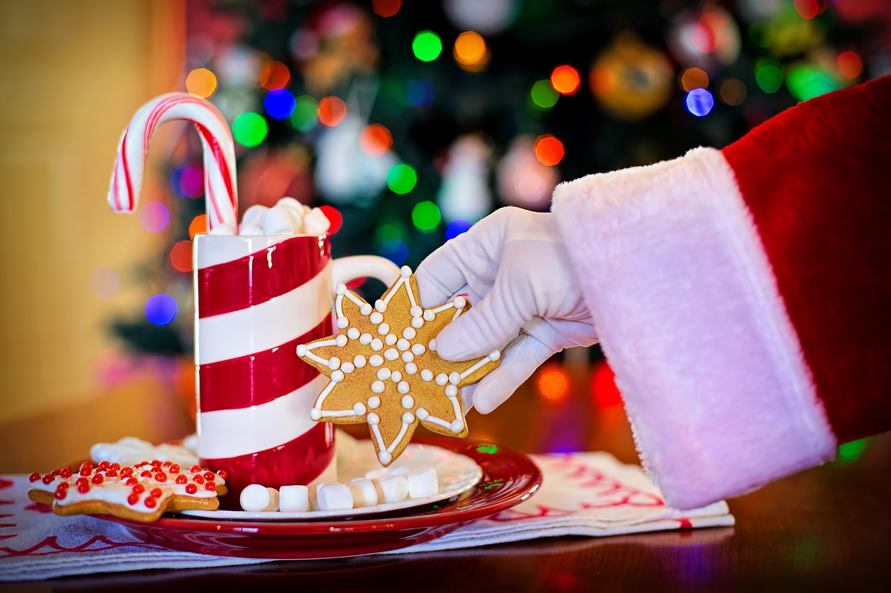 Santa Claus taking Christmas Cookie from the plate near Christmas tree. Easy Christmas Cookie Recipe